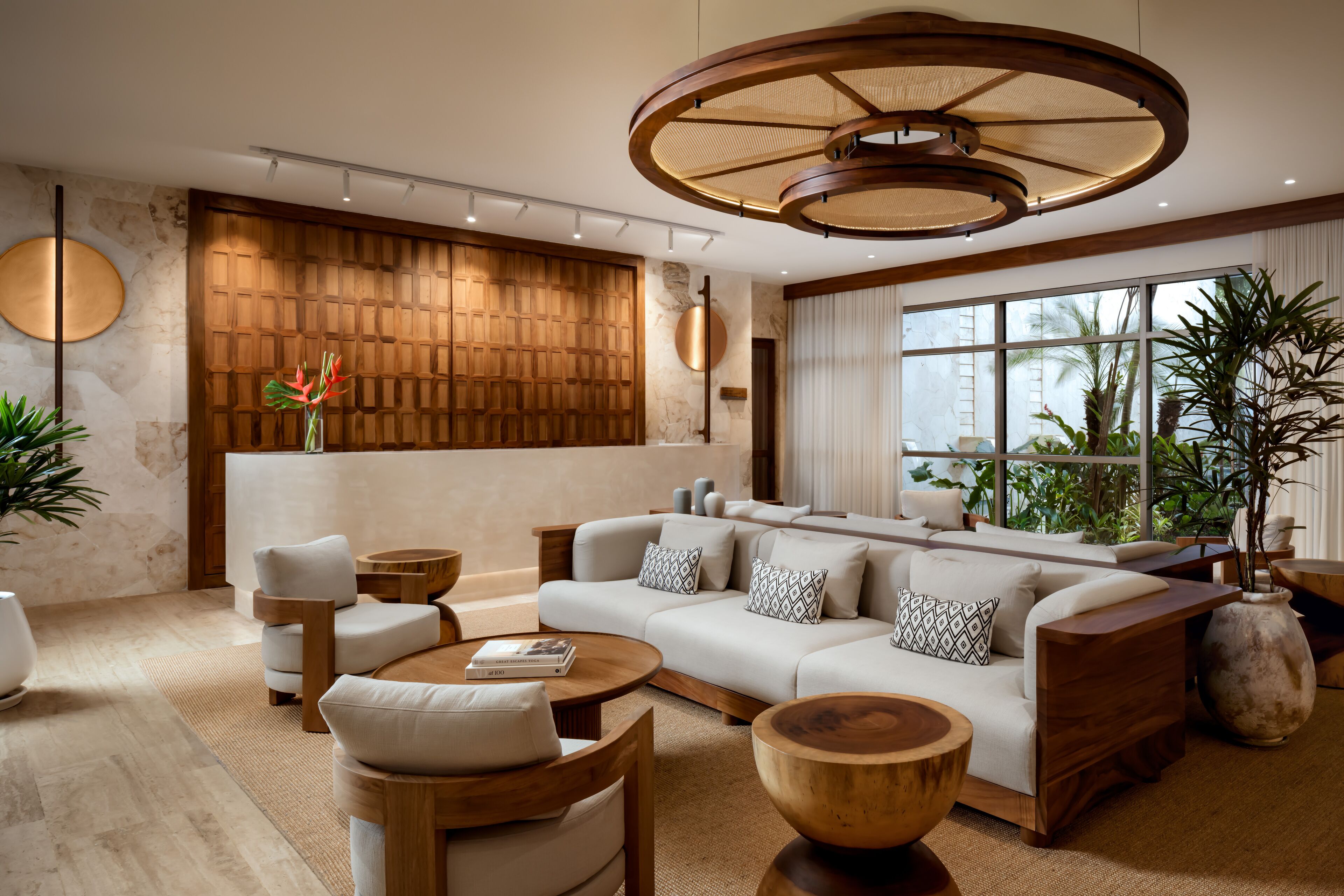 A modern living room with a large sofa, wooden coffee table, and a unique ceiling light fixture.