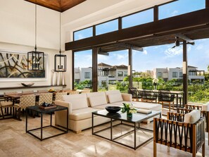 A spacious living area with a large window, a sofa, a coffee table, and a dining set. - Fairmont Heritage Place Mayakoba (Playa del Carmen)