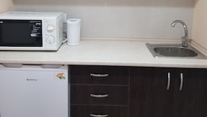 Una cocina equipada con microondas, lavavajillas y fregadero.