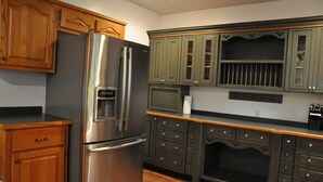 Une cuisine avec des meubles en bois, un réfrigérateur en acier inoxydable et un four à micro-ondes.