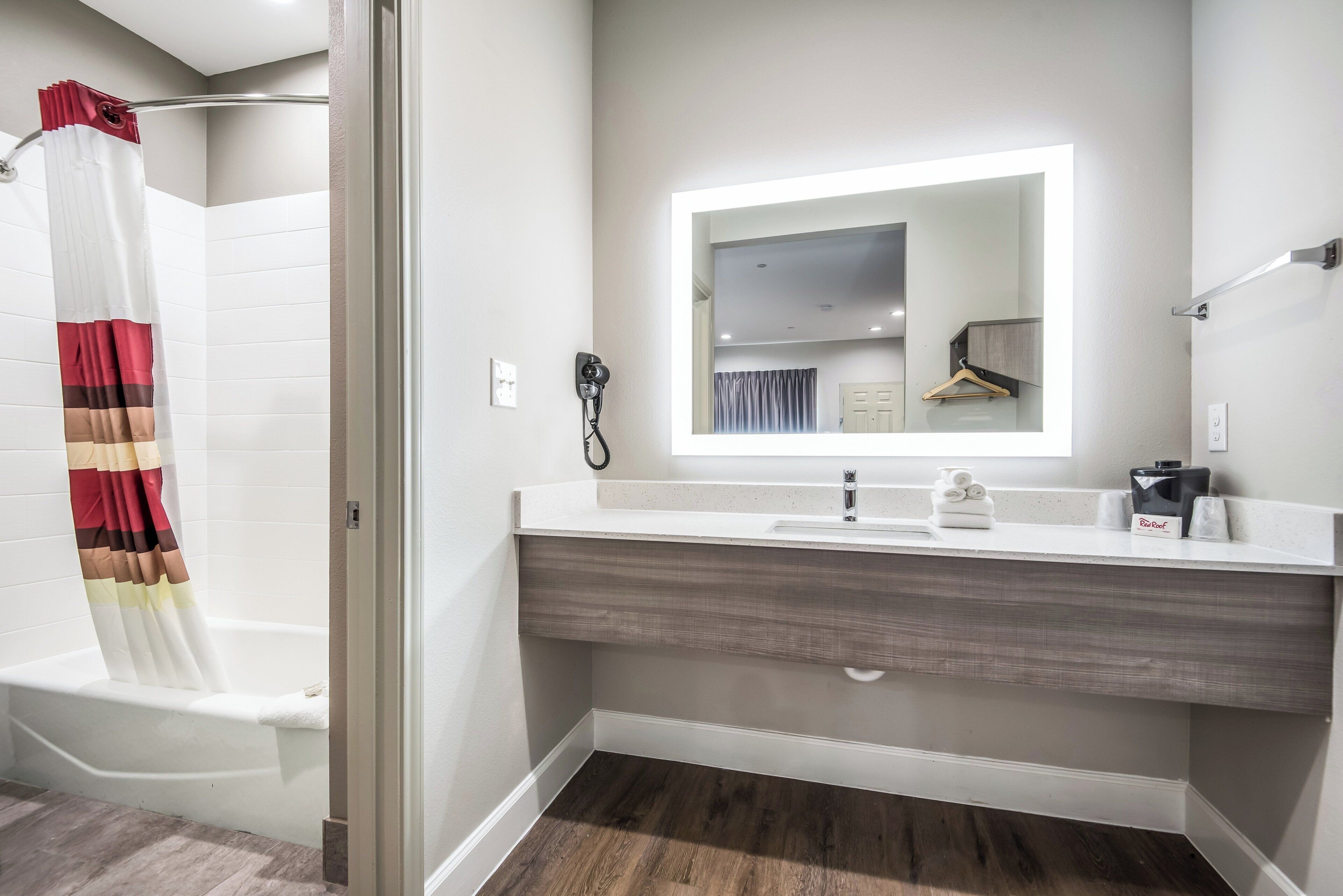 A modern bathroom with a shower curtain, a mirror, a sink, and a towel rack.