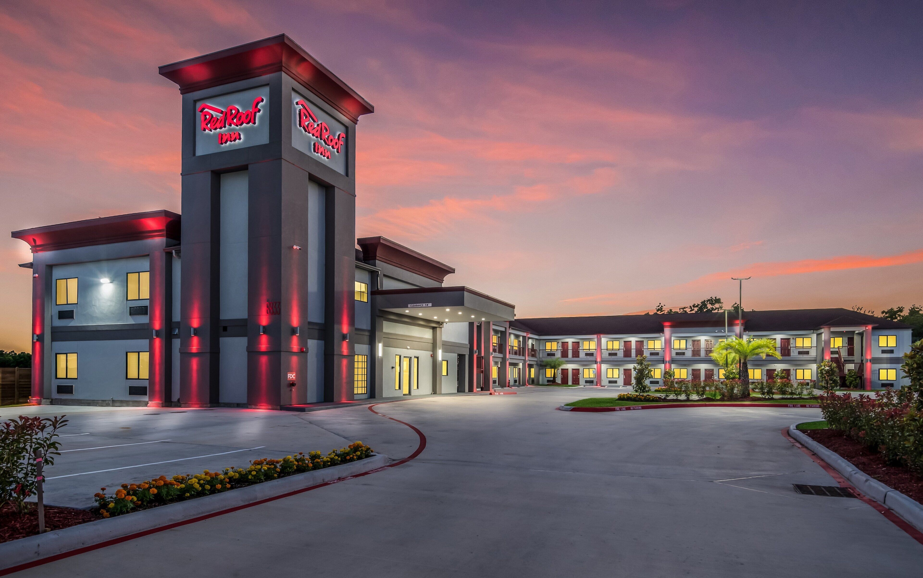 Een Red Roof Inn met een modern design, met een opvallende toren met signage, een overdekte ingang en een aangelegde oprit.