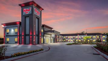 Een Red Roof Inn met een modern design, met een opvallende toren met signage, een overdekte ingang en een aangelegde oprit.