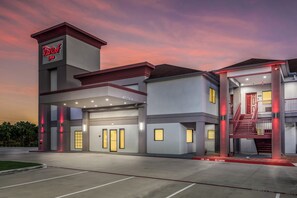 A hotel with a modern design, featuring a prominent entrance with a red awning and a sign. - Red Roof Inn Baytown (Baytown)