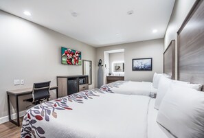 A hotel room with two beds, a desk, a chair, a television, and artwork on the walls. - Red Roof Inn Baytown (Baytown)
