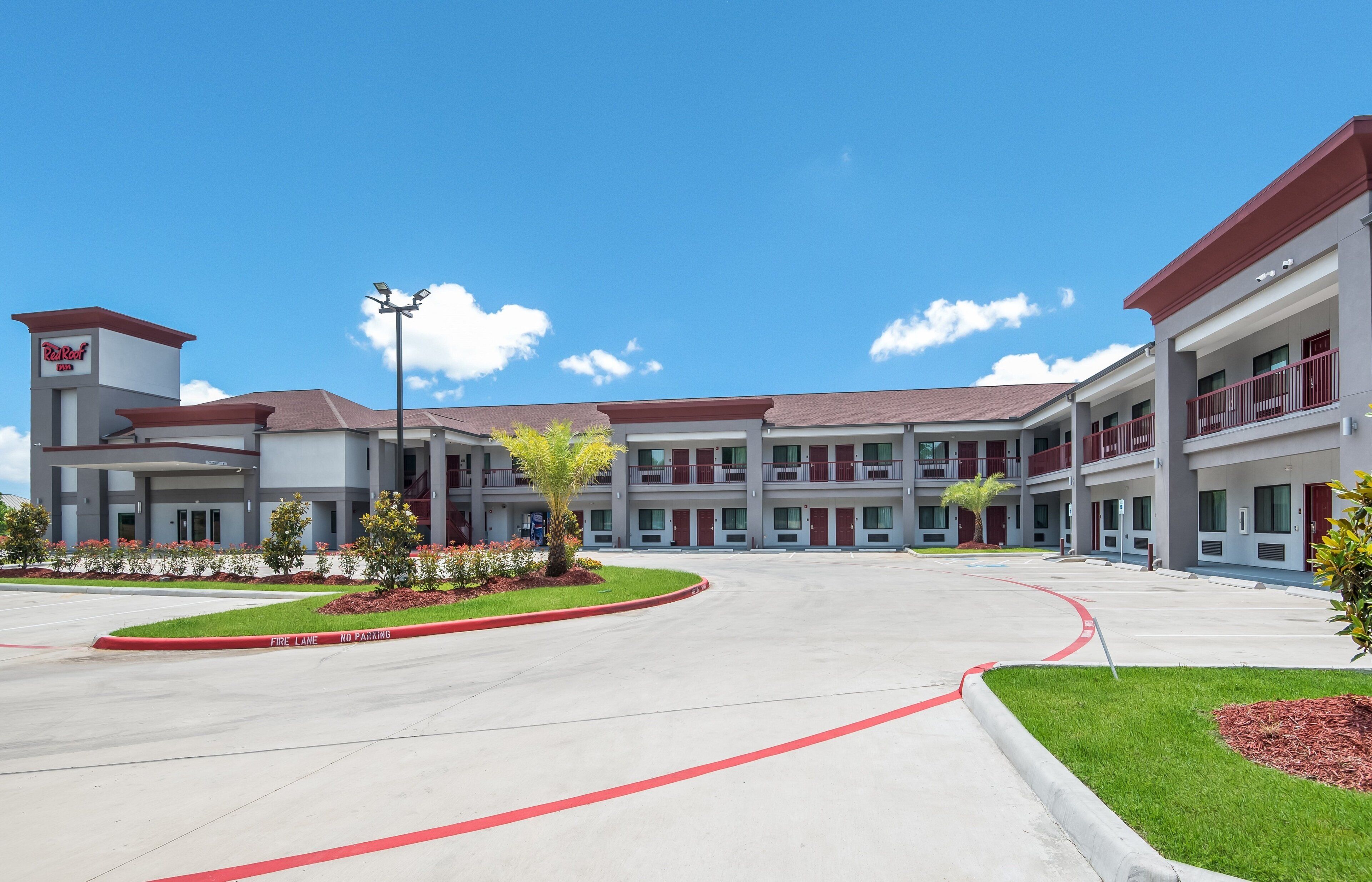 Un hotel moderno con un patio central, varios pisos y un cielo despejado.