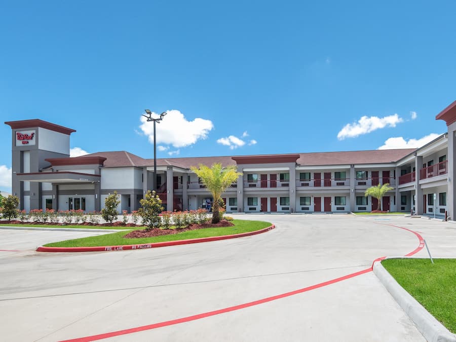 A modern hotel with a central courtyard, multiple floors, and a clear sky.