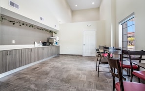 A spacious kitchen with modern appliances and a dining area with chairs and a table. - Red Roof Inn Baytown (Baytown)