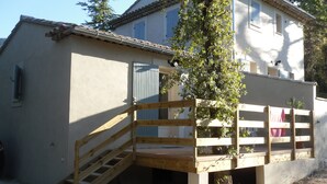 En toetagers bygning med en trætrap, der fører op til en balkon.