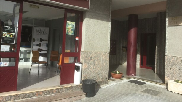 Exterior de un restaurante llamado 'Sanzala Cafés', con un letrero que indica que es un restaurante de petiscos.