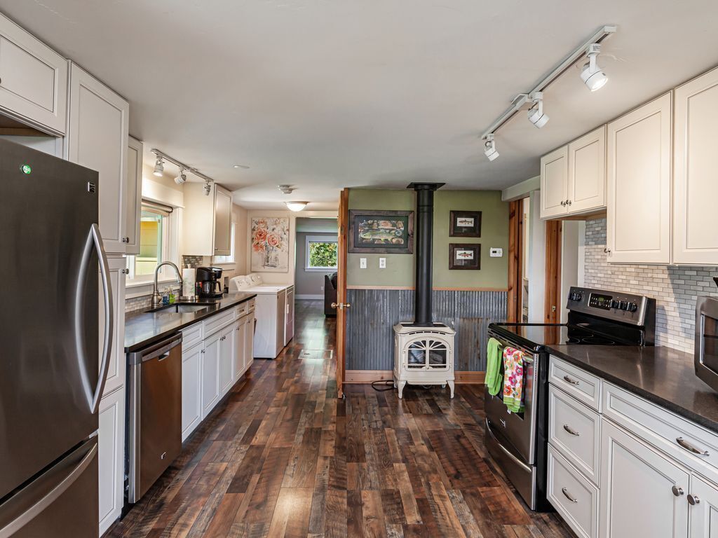 A modern kitchen with stainless steel appliances, white cabinetry, and a central island.