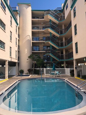 Guests can enjoy a refreshing swim in the central courtyard pool surrounded by comfortable outdoor seating.