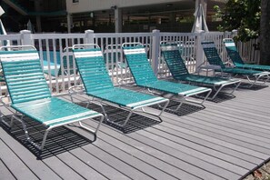 Relax in comfort on the outdoor deck with lounge chairs arranged along a picket fence.