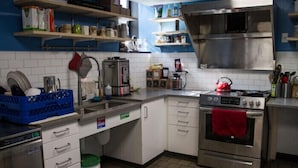 Uma cozinha com armários brancos, eletrodomésticos de aço inoxidável e paredes azuis.