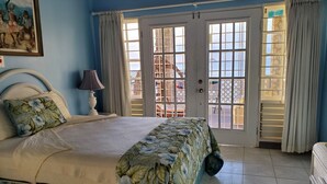 Una camera da letto con un letto, un comodino, una lampada e una finestra con tende.