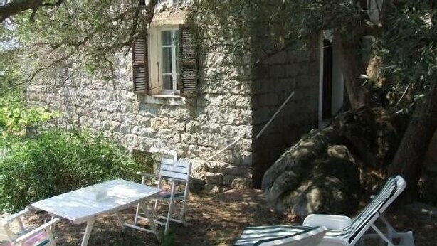 Un edificio in pietra con un piccolo tavolo e due sedie all'esterno.