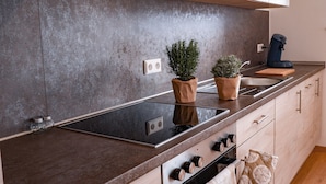 Una cocina moderna con encimera de granito, estufa integrada y armarios de madera.