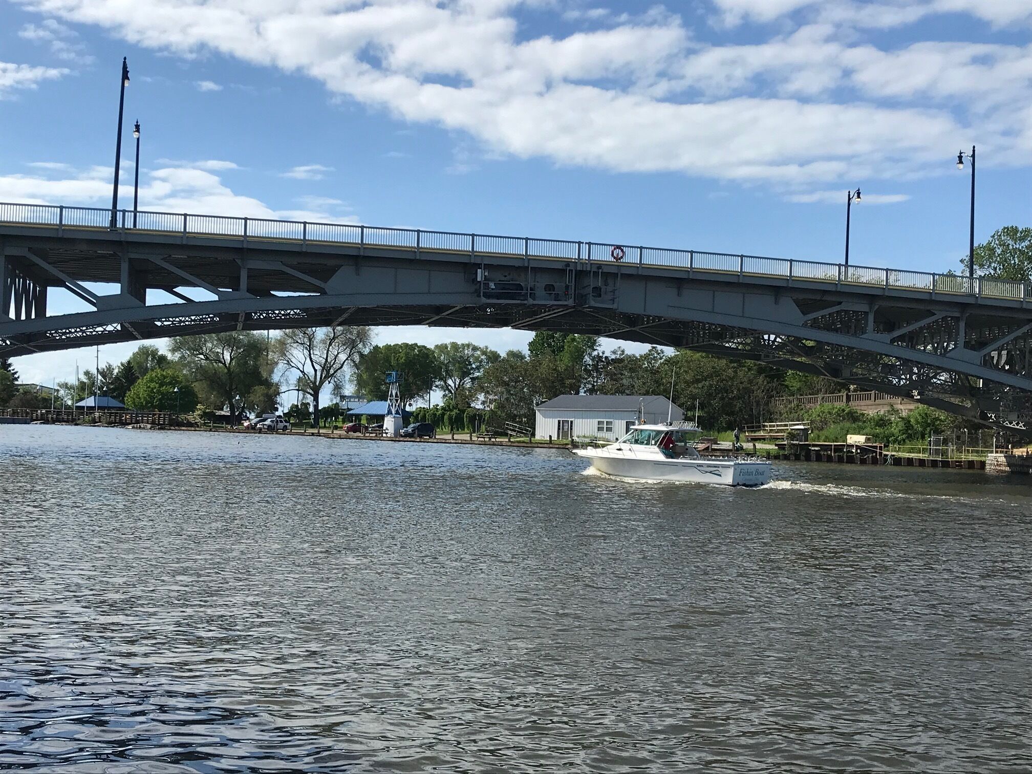 Un puente sobre un río con una embarcación llamada 'Ethan's Boat' pasando debajo.