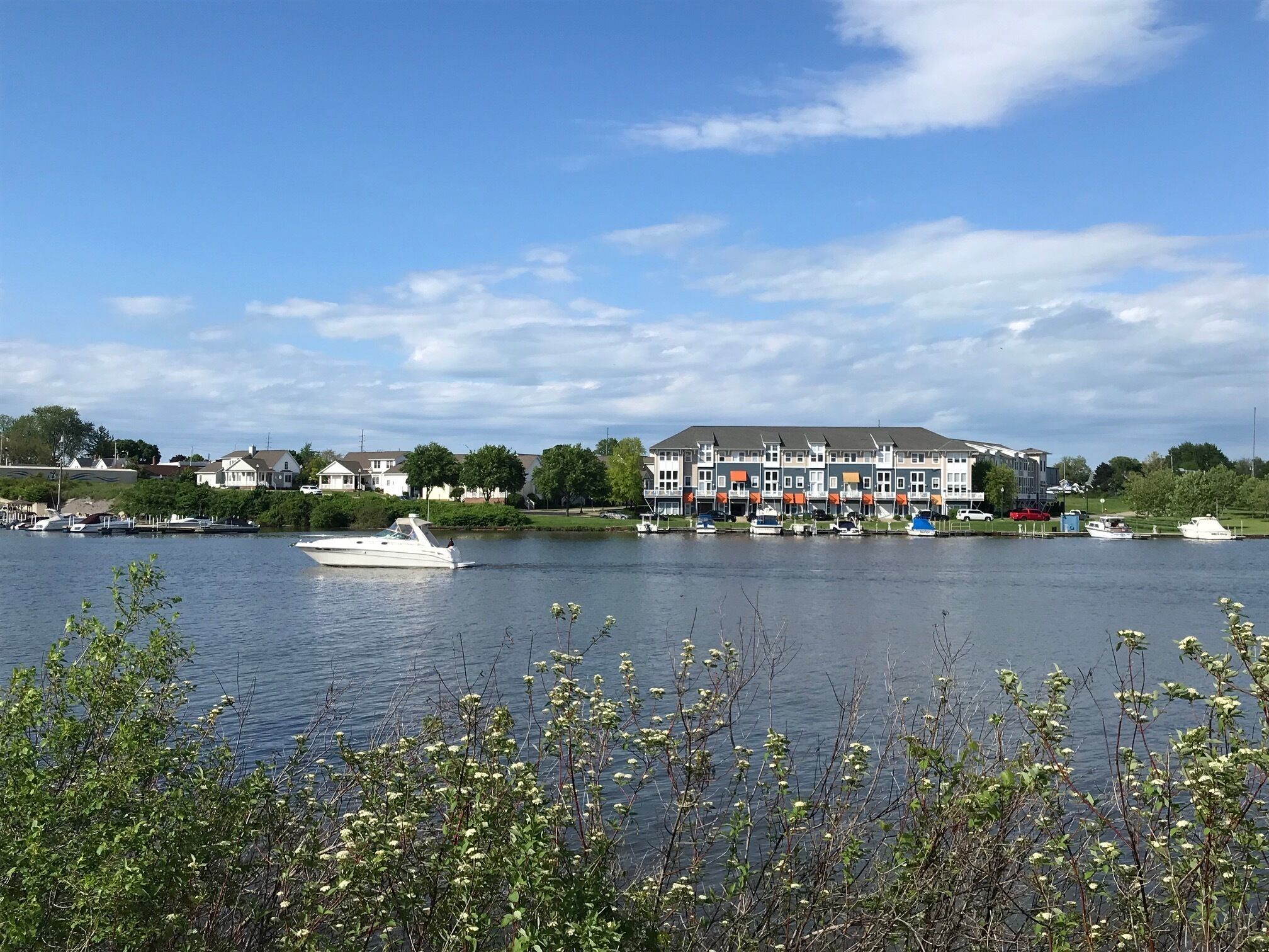 Uitzicht op het water met een rij huizen en een hoog gebouw.