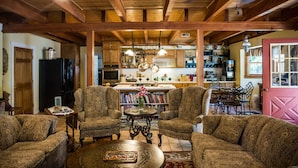 A cozy living room with patterned furniture, a dining area, and a kitchen in the background. - Mountain Harbour B&B and Hiker Hostel (Roan Mountain)