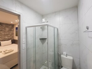 Quarto casal básico | Banheiro | Chuveiro, toalhas de banho, papel higiênico 