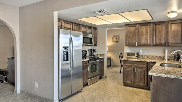 A modern kitchen with stainless steel appliances, wooden cabinets, and a granite countertop. - Near Starr Pass-Downtown- U of A  3 Bedoom Home (Tucson)