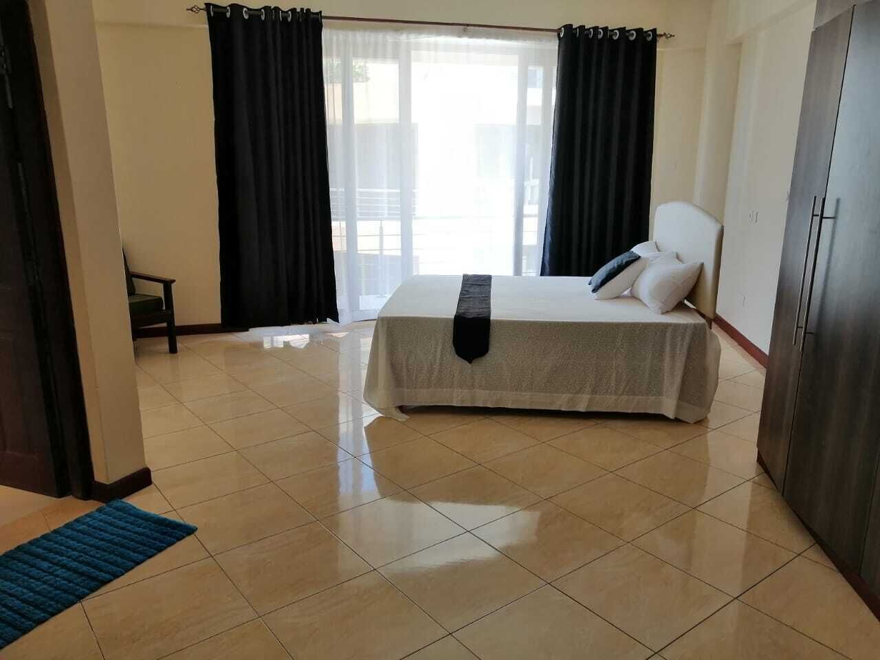 Une chambre d’hôtel avec un lit, une chaise, une armoire et une vue par la fenêtre.