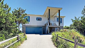 A two-story house with a covered porch and a garage. - Gorgeous beach views Walk to beach Theater room (Gulf Shores)