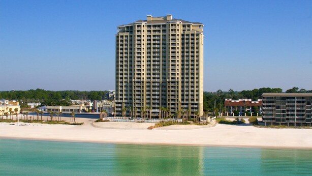 A tall, multi-story hotel with a modern design, located near a beach with clear blue water. - September Reduced Rates !! VIP Beach Chair service Included (Panama City Beach)