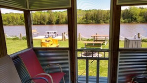 A covered outdoor seating area with a view of a lake and picnic tables. - Waterfront Private Campground-Two extra RV hookups available - 50.00 per night   (Ontonagon)