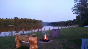 A lakeside campsite with a fire pit, a bench, and a small shed. - Waterfront Private Campground-Two extra RV hookups available - 50.00 per night   (Ontonagon)