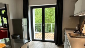 Une cuisine moderne avec une porte-fenêtre coulissante donnant sur un balcon.