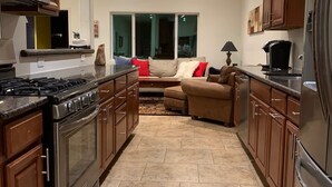 Una cocina moderna con armarios de madera, un refrigerador de acero inoxidable y un horno empotrado.
