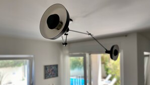 Una lámpara fijada al techo en una habitación con ventana y puerta que da al exterior.