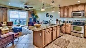A spacious kitchen with a large island, wooden cabinets, stainless steel appliances, and a view to the outside. - 5th floor, Gulf views, 2 Pools, Free Beach Service, Garage Parking (Miramar Beach)