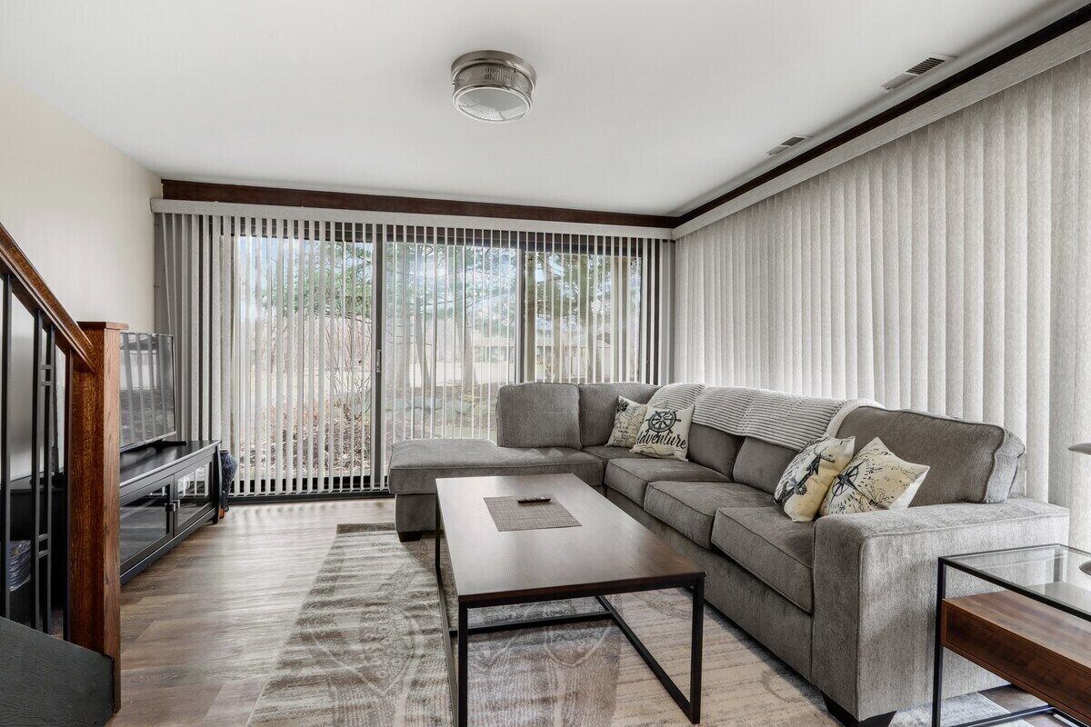 A modern living room with a sectional sofa, a coffee table, and a TV.