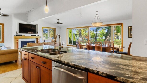 A spacious kitchen with granite countertops, wooden cabinets, and a built-in dishwasher. - Lake Benedict Lakefront Home with Fire Pit Large Yard Kayak Friendly (Genoa City)