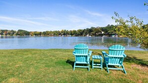 Two Adirondack chairs facing a lake with ducks swimming. - Lake Benedict Lakefront Home with Fire Pit Large Yard Kayak Friendly (Genoa City)