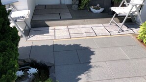 Une entrée avec une porte blanche, une boîte aux lettres, une statue et une chaise.