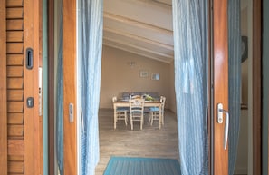 Une pièce comprenant une table à manger et des chaises, un canapé et un plancher en bois.