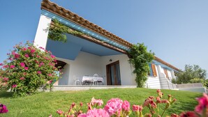 Una casa con portico coperto, una porta e un tavolino con sedie.