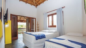 A room with two beds, a TV, and a balcony with a wooden ceiling.