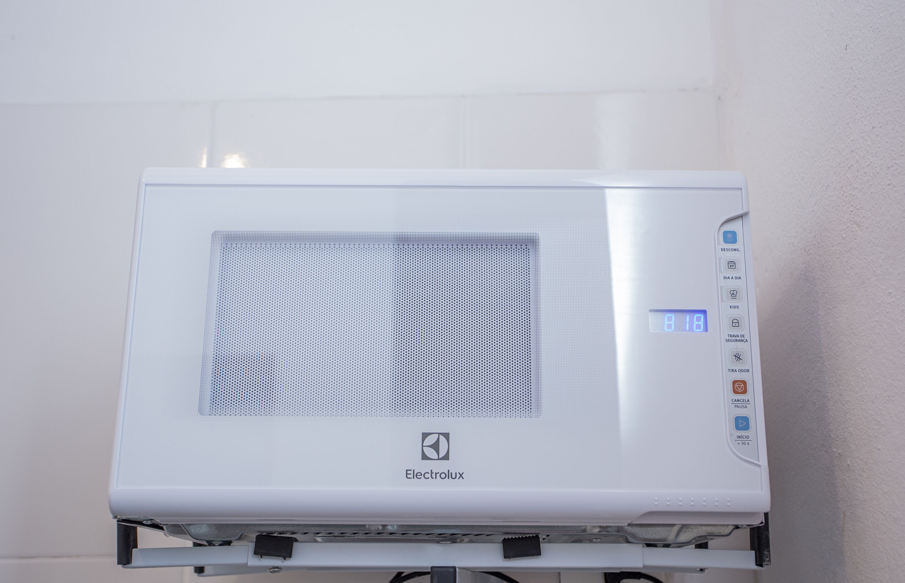 Un four à micro-ondes Electrolux blanc, doté d’un écran numérique, d’un panneau de commande avec différents boutons et d’une grille d’aération.