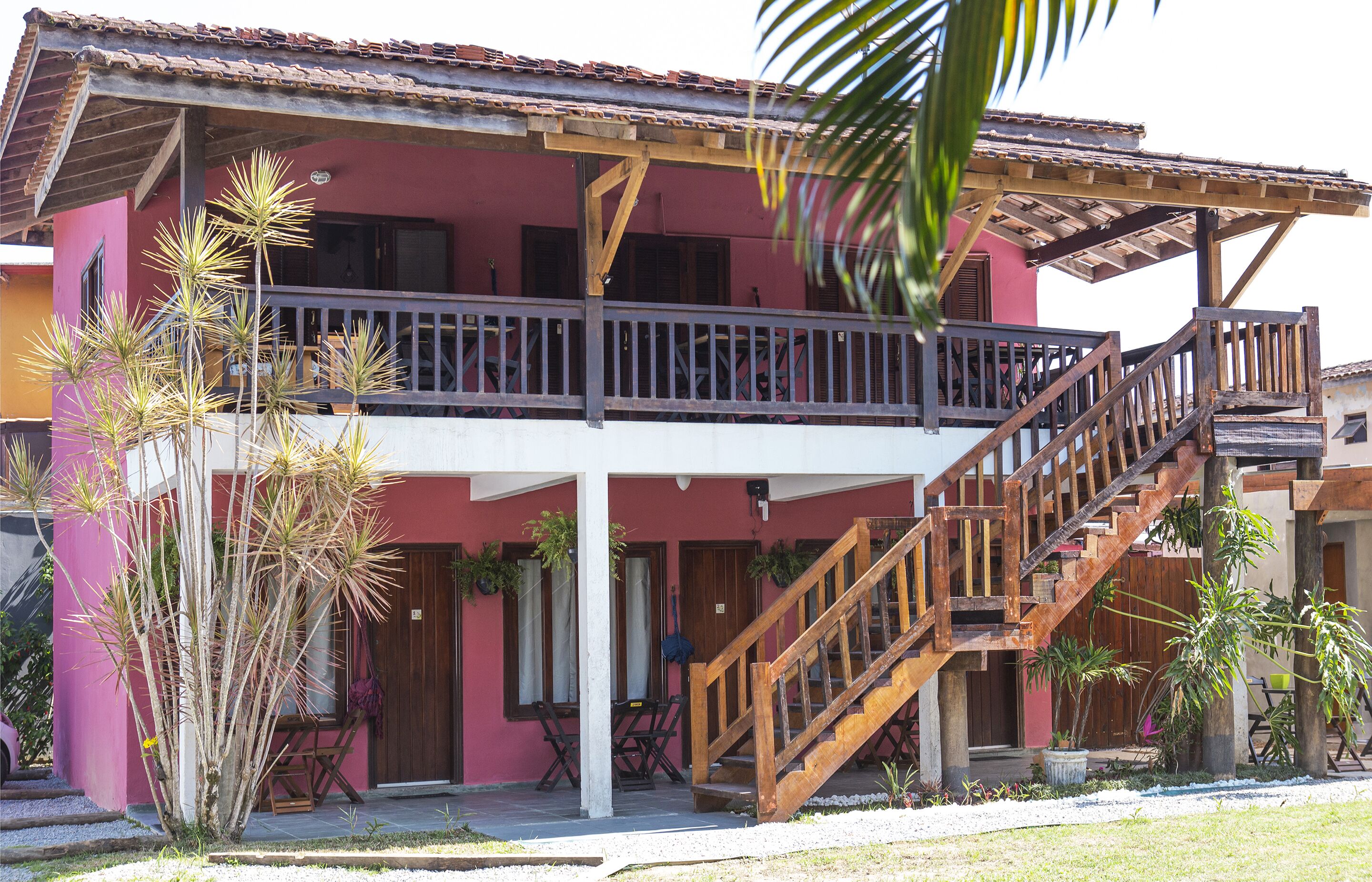 A two-story building with a balcony and wooden staircase.