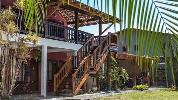 A two-story building with a wooden staircase, outdoor seating area, and a covered patio.