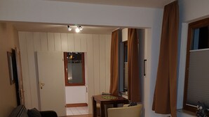 A hotel room with a bed, a sofa, a small table, and a desk. - Hansa Apartments Hamburg - Apartment 1B (Wandsbek)