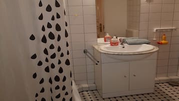 Bathtub, hair dryer, towels, toilet paper