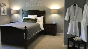 A neatly arranged bedroom with a bed, bedside lamps, a dresser, and a wall with motivational text. - Lower Level Entry Home with private Patio & back yard. (Nanaimo)