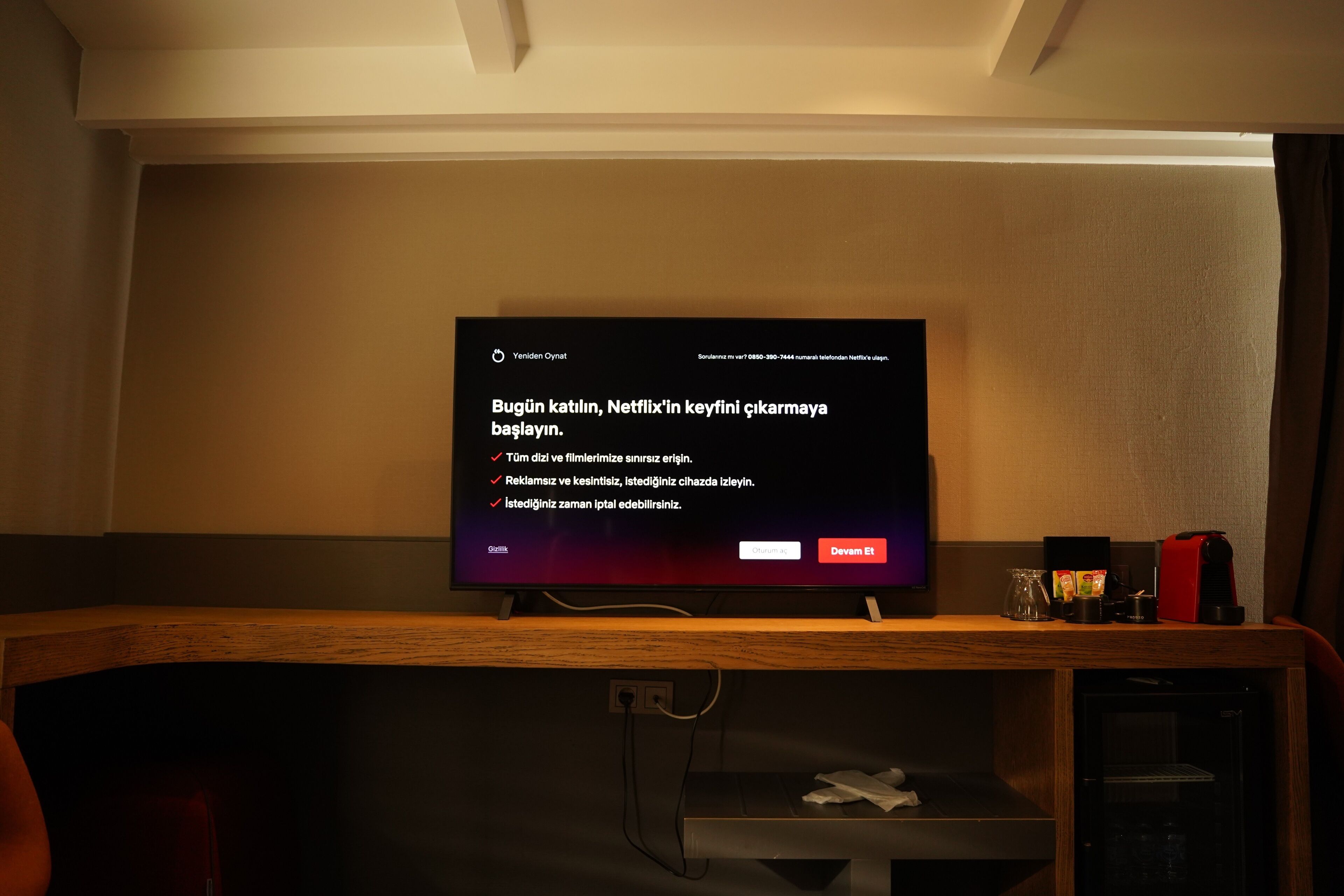 A television mounted on a wall displaying a message in Turkish.