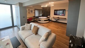 Una sala de estar moderna con un sofá, un televisor y una zona de estar circular.
